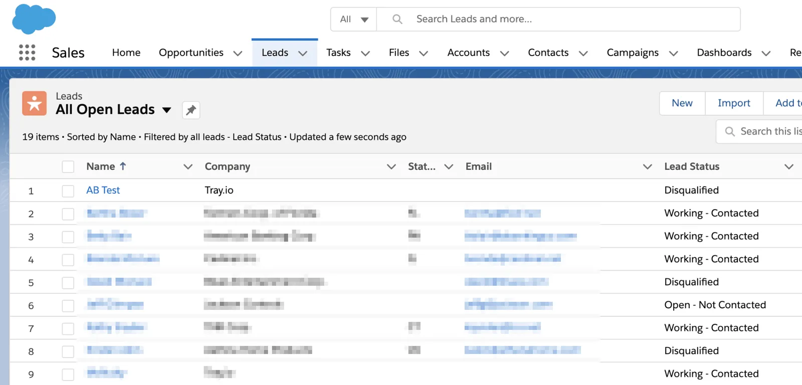 Salesforce 'All Open Leads' list view with name, company, email and lead-status columns; lead names and emails blurred for privacy